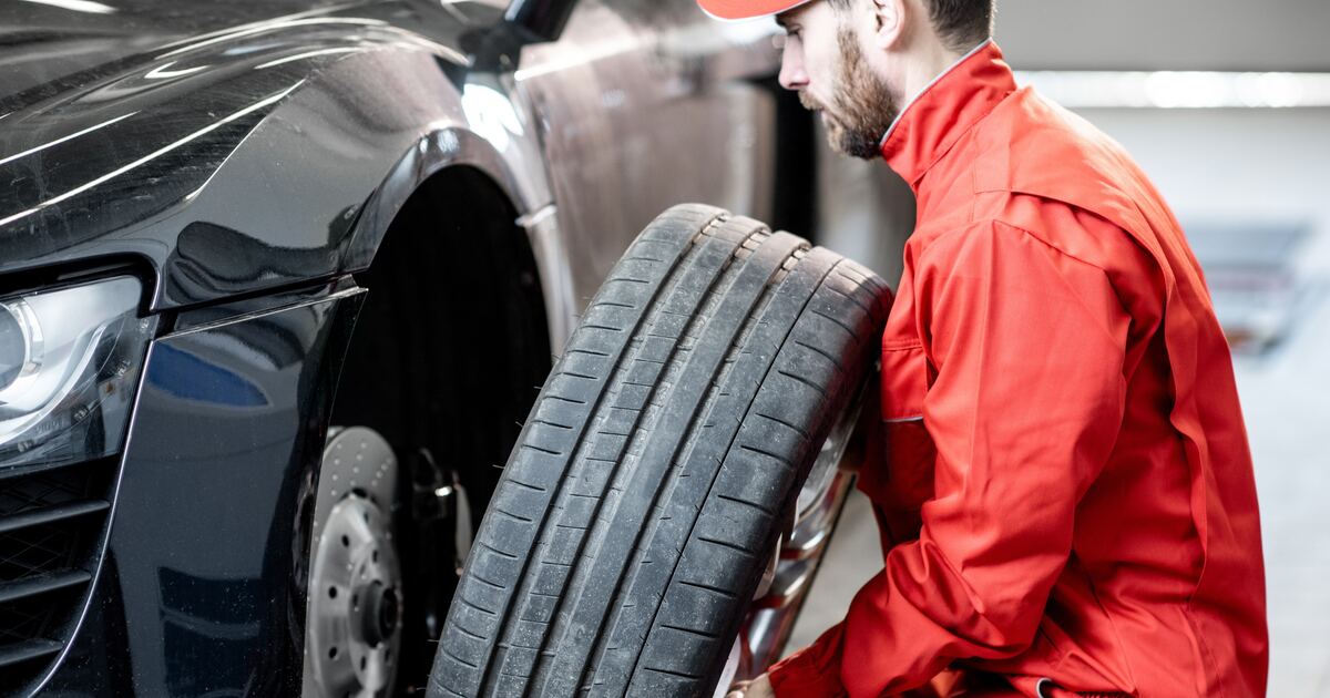 Tyre fitter fitting a new tyre to a car